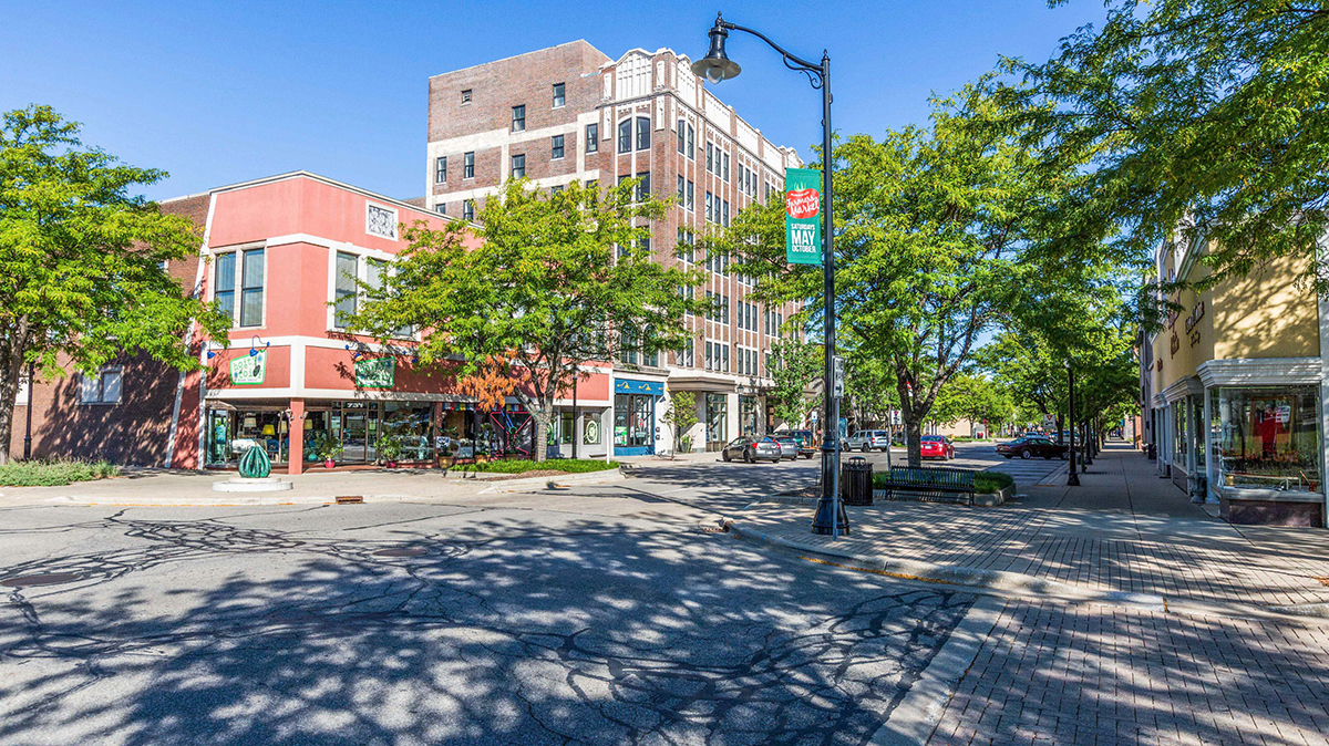 View of downtown Michigan City, Indiana with historic buildings, tree-lined streets, and storefronts.